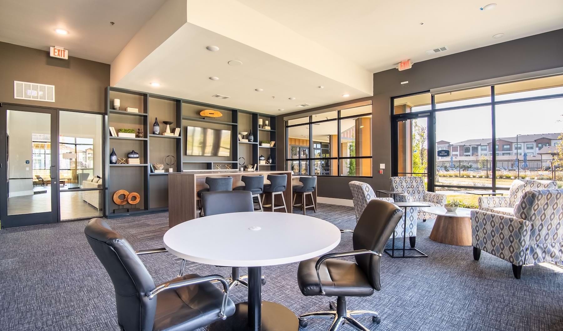 Enjoy our resident-only features a room with a table chairs and shelves and large windows