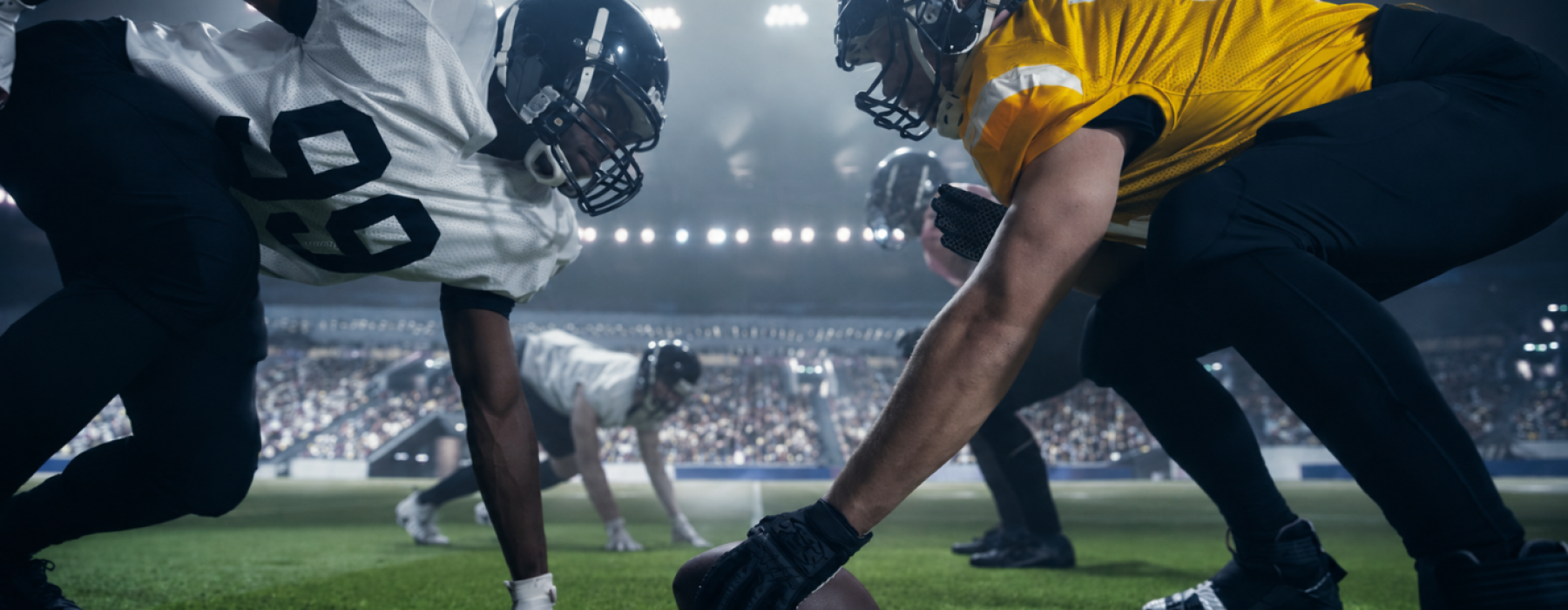 Football linemen facing off at the line of scrimmage at AT&T Stadium in Arlington TX