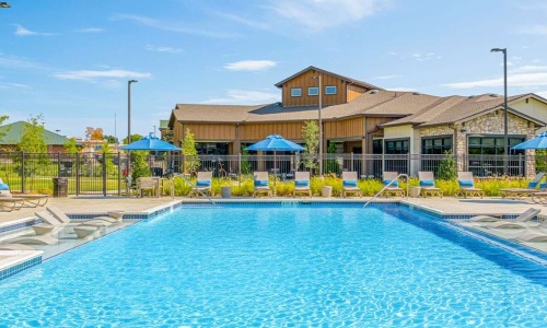 Relax by the resort-style swimming pool and sun deck at Creekside at Grand Prairie apartments.